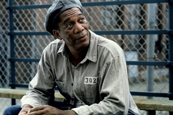 A dark-skinned man in a prison uniform