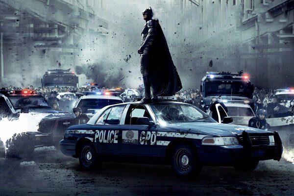 Batman debout sur une voiture de police