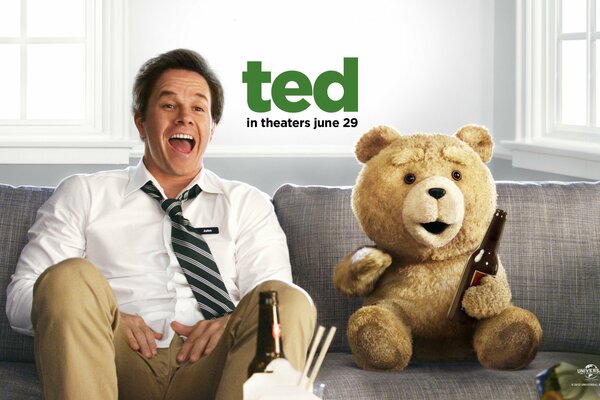 I personaggi del Film Third Extra Ted E Mark Wahlberg sono seduti sul divano ridendo e bevendo birra