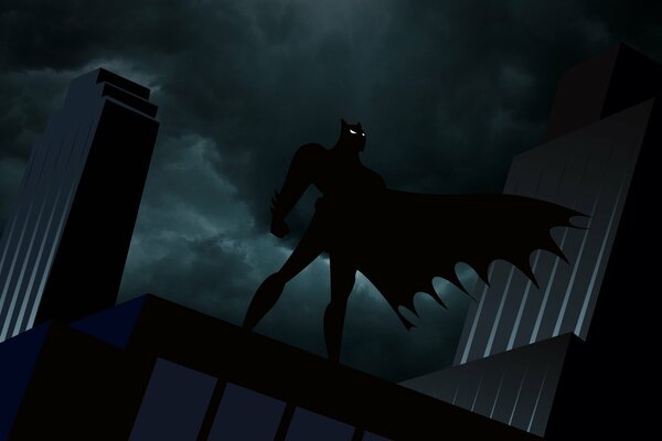 Batman in a flowing cape on the roof at night