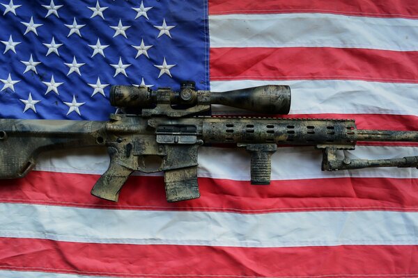 The gun on the background of the flag. The flag of America. Old weapons