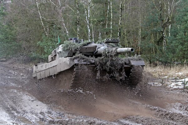 A battle tank is driving on the road