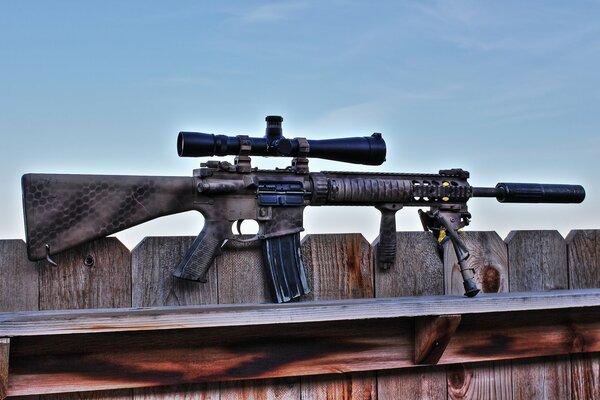 Assault semi-automatic rifle on the background of a fence