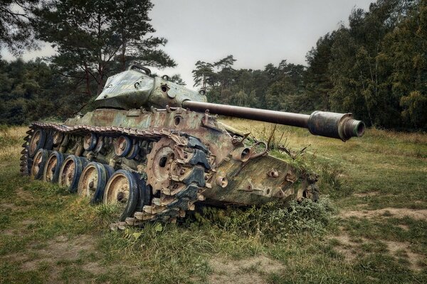 El tanque se inclinó en el campo sobre la hierba en tiempo nublado