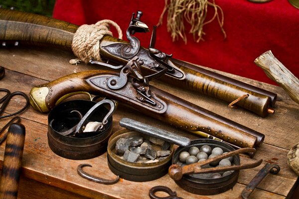 Antique pistols are lying on a wooden table