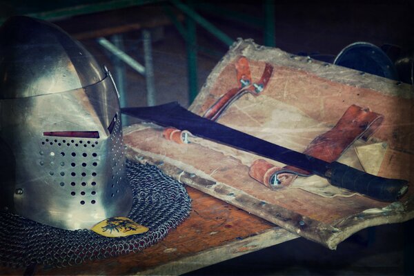 Helmet and sword on the background of chain mail