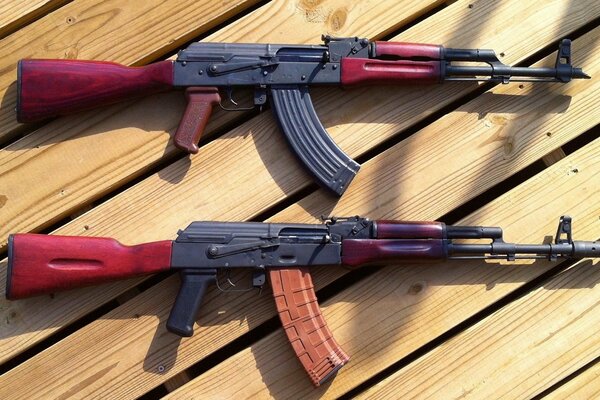 Dos fusiles de asalto Kalashnikov en un piso de madera