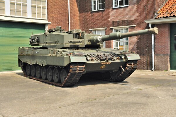 A battle tank is standing at the house