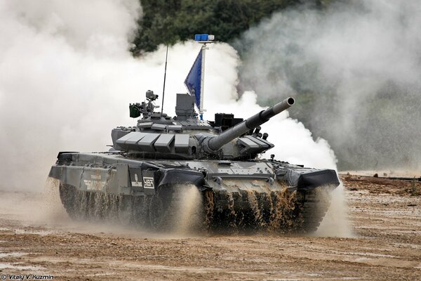 T-72 b3 tank rides on sand in smoke