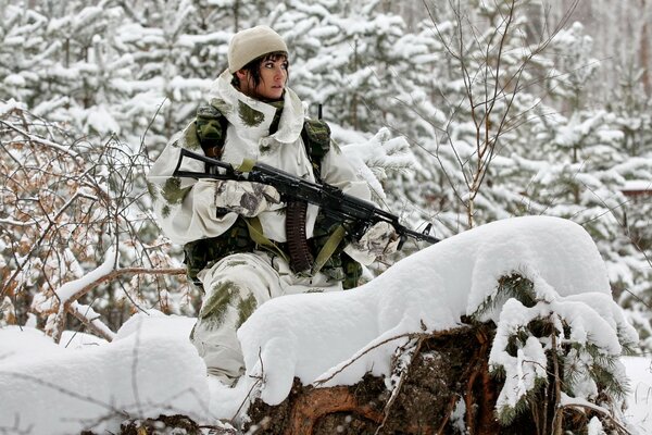 A girl in camouflage with a machine gun in her hands