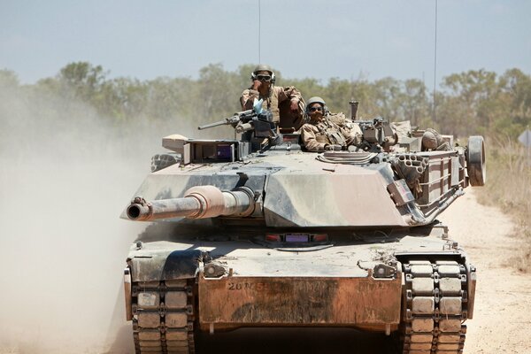 Soldados posando sentados en un tanque