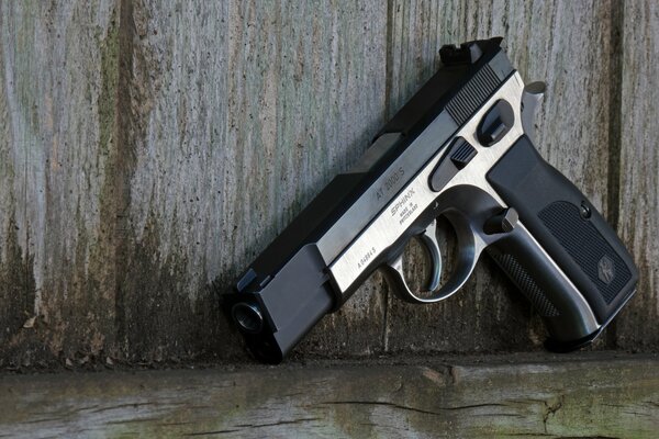 Self-loading pistol on the background of a fence