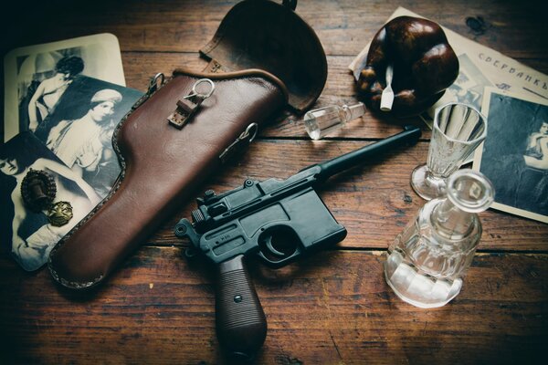 Die Waffe liegt auf dem Tisch neben dem Glas