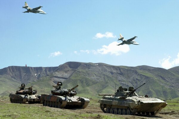 Tanques y aviones de ataque en el fondo de las montañas