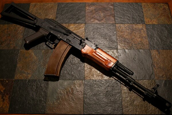 Kalashnikov assault rifle lying on the kitchen tile