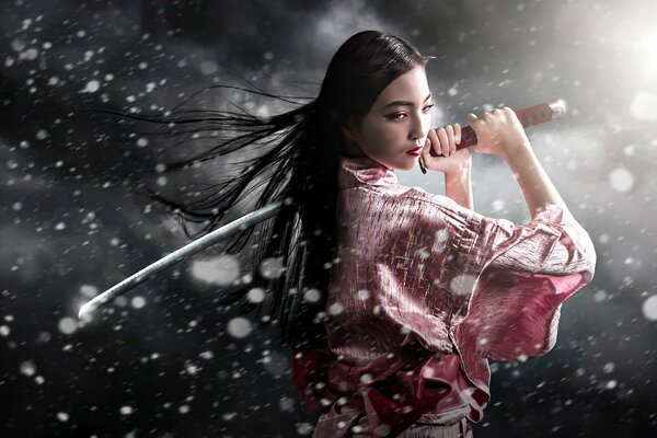 Beautiful girl with a sword in the snow