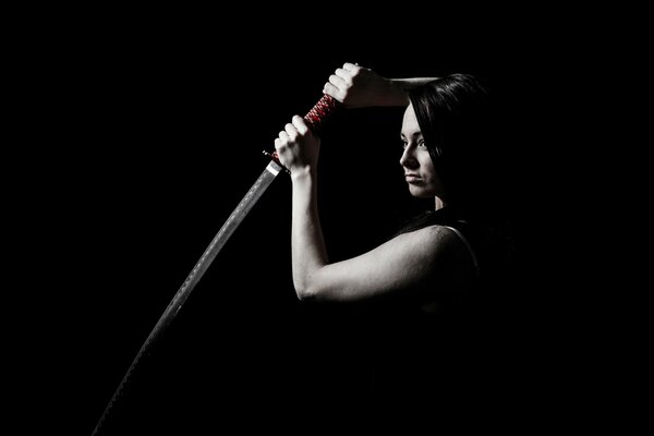 Fille avec une épée sur fond noir