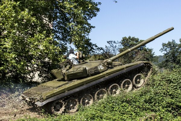 Ein mächtiger Panzer steigt bergauf . Es scheint wie ein t-72 zu sein