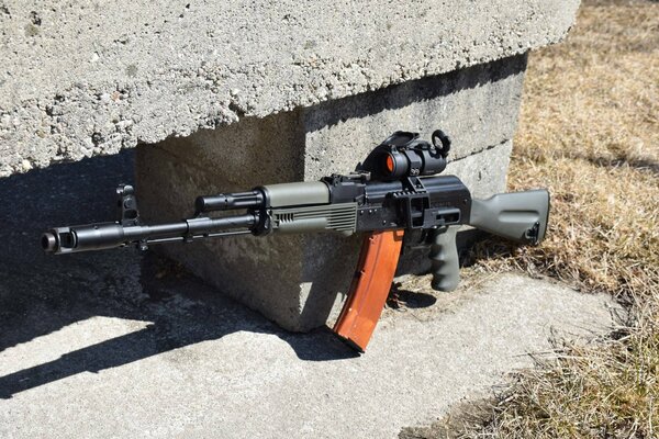 Kalashnikov assault rifle near a concrete block