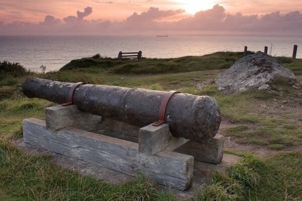 Antique cannon on wooden bars on the seashore