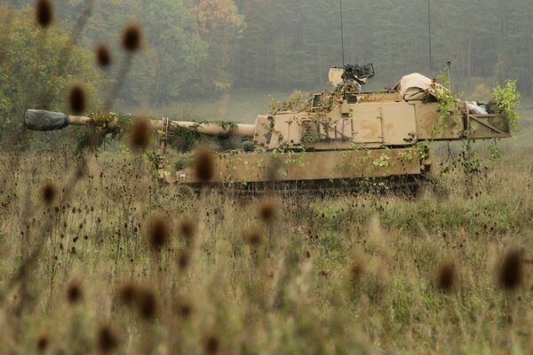 American self-propelled howitzer in the field against the background of the forest