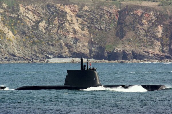 Submarine floating on the background of rocks