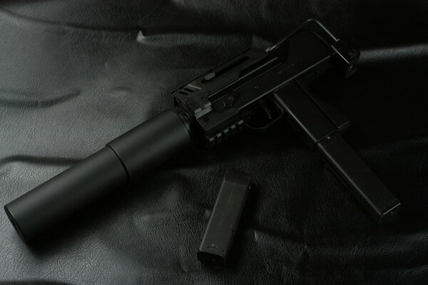 Pistol with a silencer on a black background