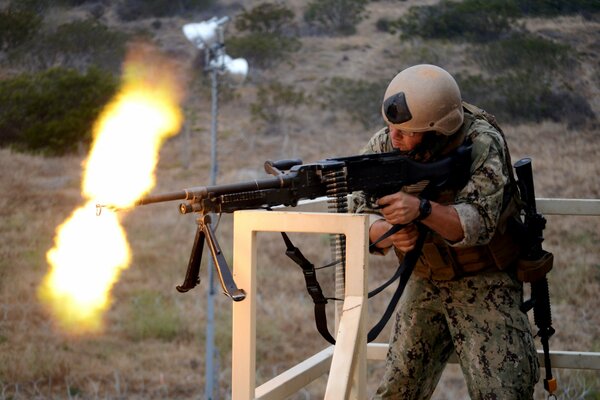 Tiro en el campo de entrenamiento por un soldado equipado de un pklemet de cinta m240b