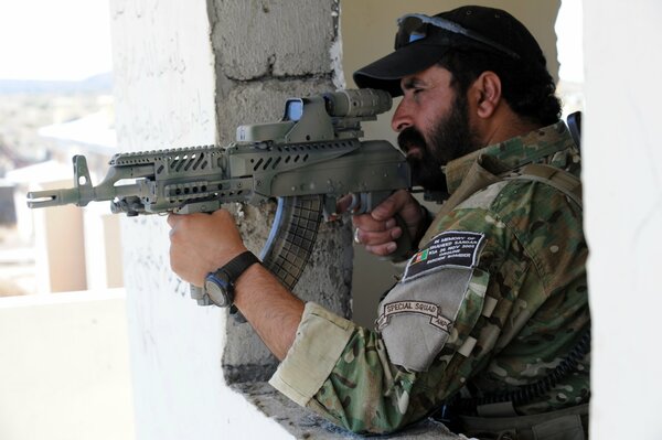 An Afghan policeman takes aim with a machine gun