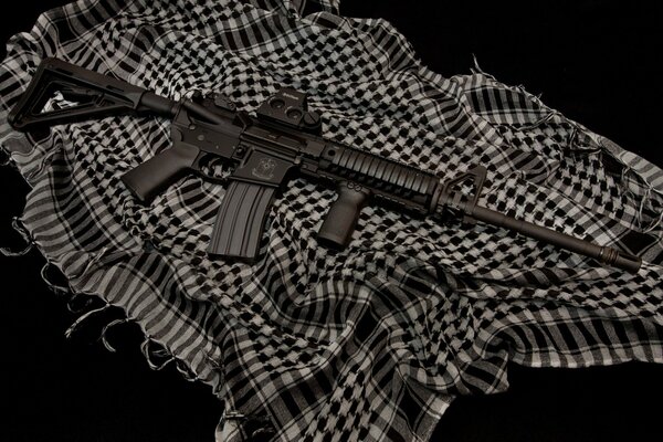 A rifle on a dark background lying on a cloth