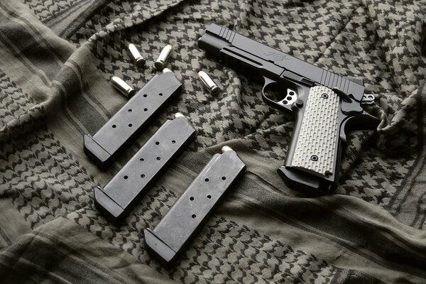 1911 pistol and magazine on fabric background