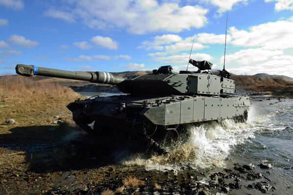 Tanque de batalla Leopard 2A6 , foto en el río con salpicaduras y cielo