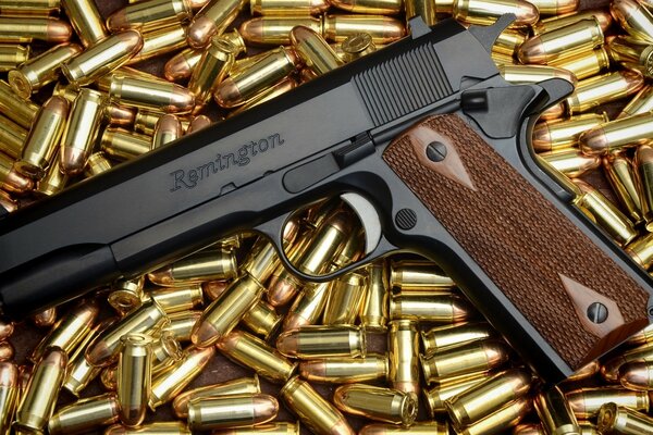 A colt pistol on a pile of cartridges