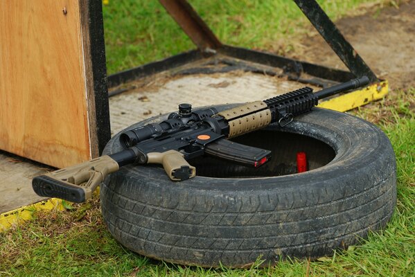 Rifle de asalto en un neumático de automóvil