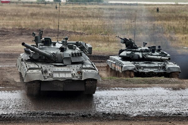 T-80 and T-90 tanks on a dirty military training ground