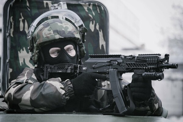 Soldat in Helm und Maske mit Maschinengewehr