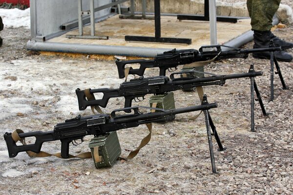 A row of three machine guns on the ground