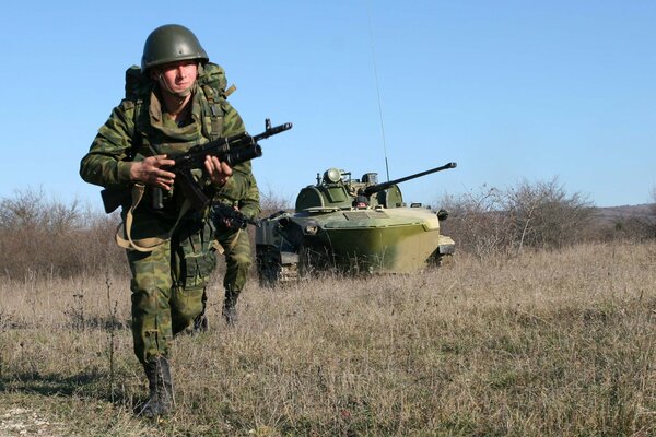 Militare con un fucile d assalto corre sul campo