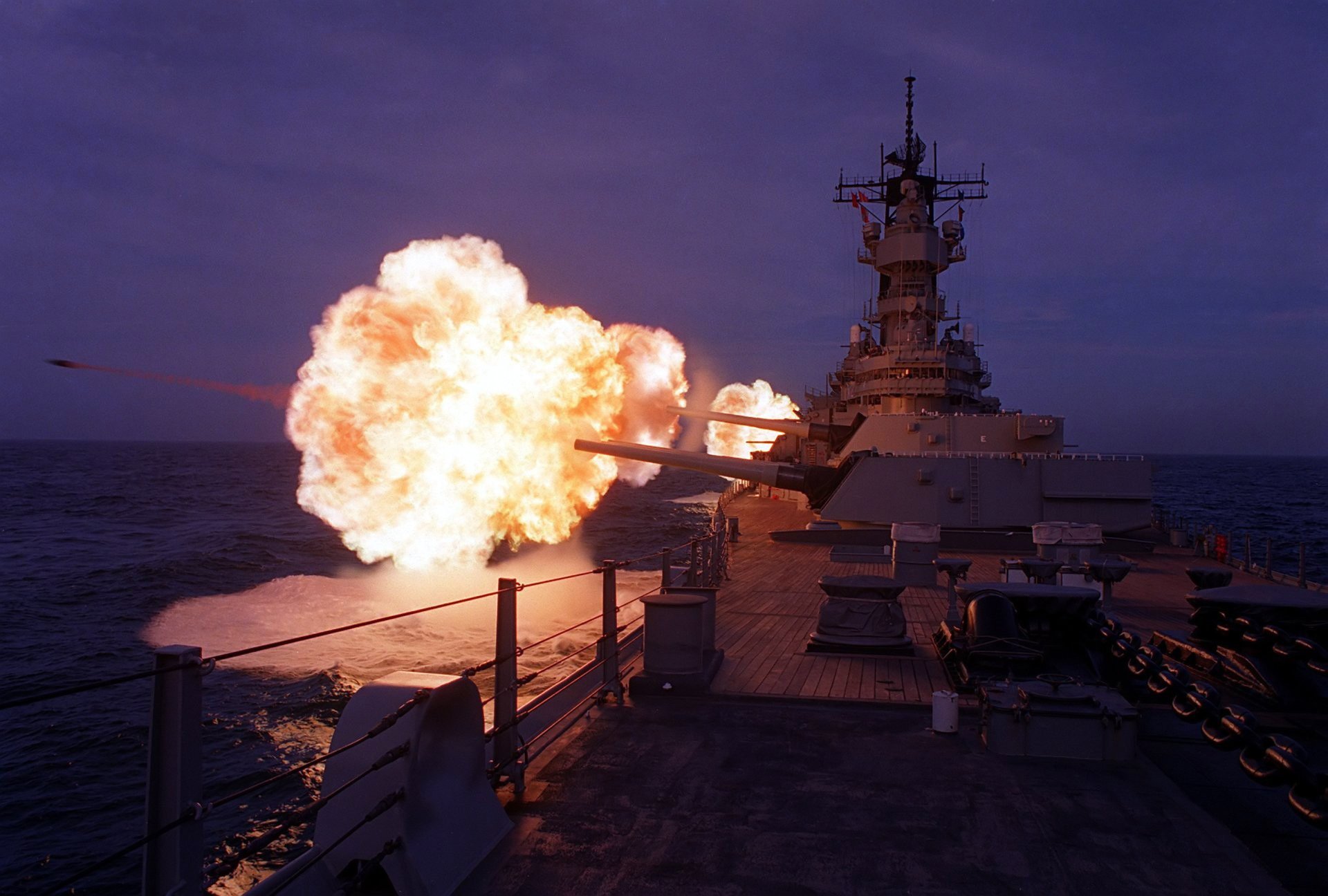 marine croiseur navire pont canons troncs canons salve coup feu explosion mer horizon ciel soir