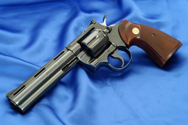 Revolver posant sur fond de satin bleu