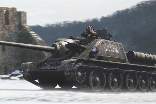 A tankman from a tank looks through binoculars