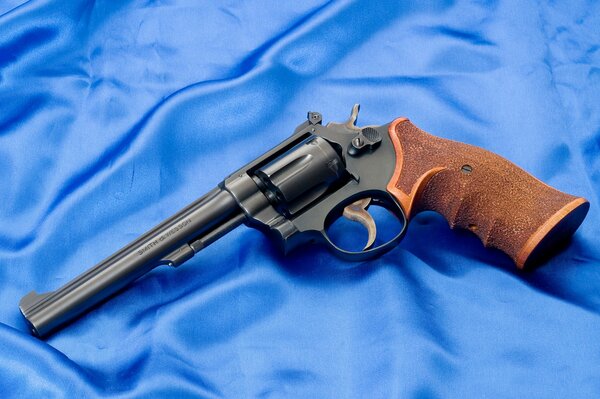 Revolver Smith e Wesson con impugnatura marrone su seta blu