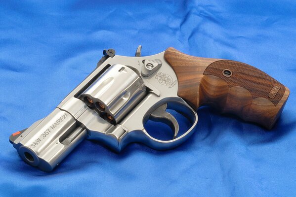 Revolver avec décoration en bois sur satin bleu