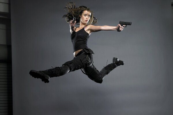 Girl jumping with pistols