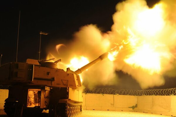 La flamme sort de M109a2. Autour du fil de fer barbelé