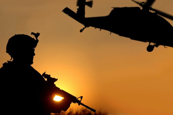 Soldat avec arme sur fond de couchers de soleil pendant la guerre