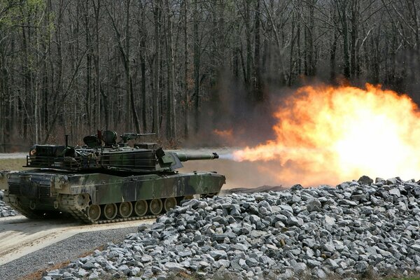 The tank drives along the road and shoots