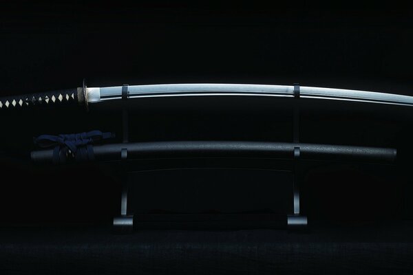 Elegant katana on a stand and a black background