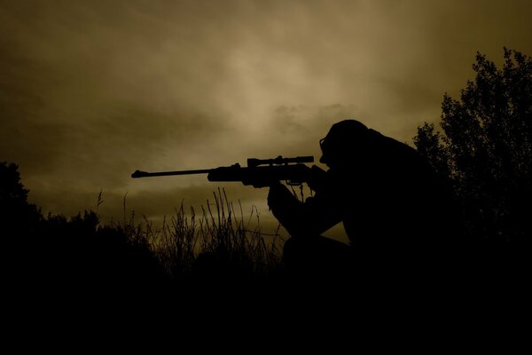 Francotirador en un campo oscuro con armas