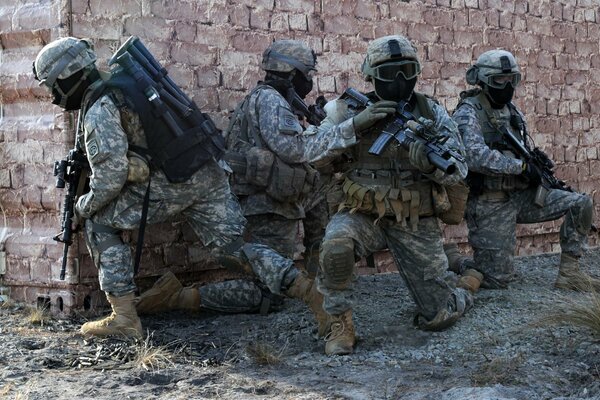 Soldados a la vuelta de la esquina de la casa en uniforme militar